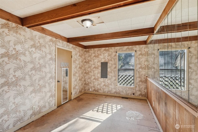 unfurnished room with beam ceiling and electric panel