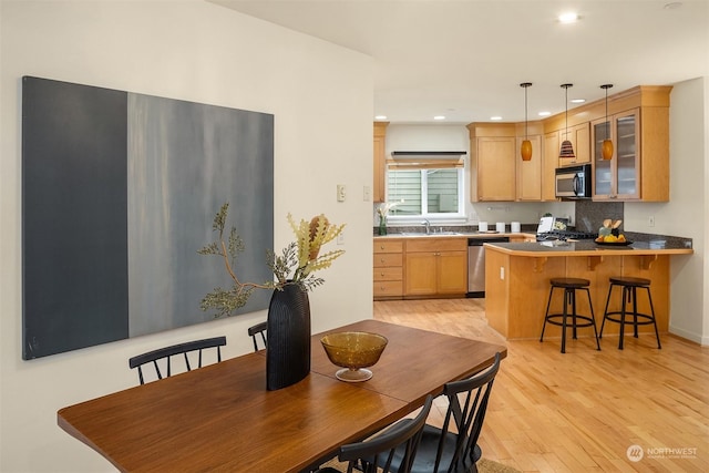 dining space featuring sink and light wood-type flooring