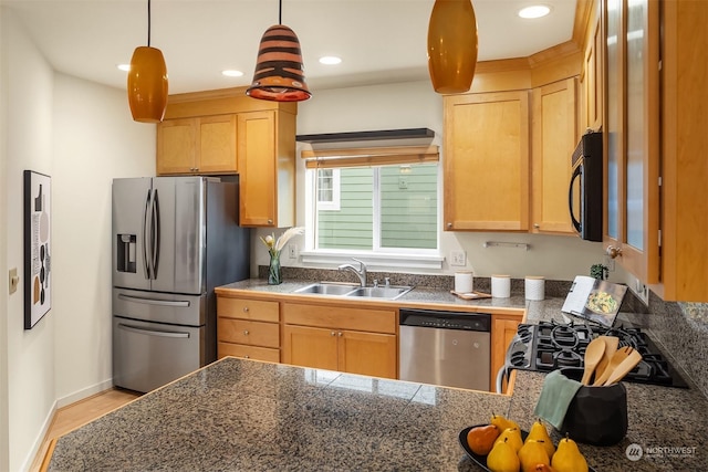 kitchen featuring sink, light hardwood / wood-style flooring, hanging light fixtures, light brown cabinets, and appliances with stainless steel finishes