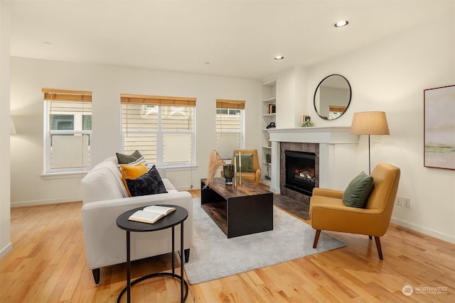 living room with light hardwood / wood-style floors and a tile fireplace