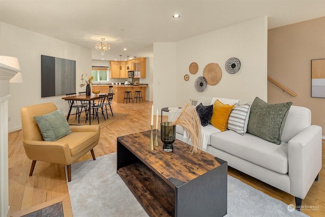 living room featuring a chandelier and light hardwood / wood-style floors