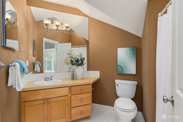 bathroom with vanity, tile patterned flooring, vaulted ceiling, and toilet