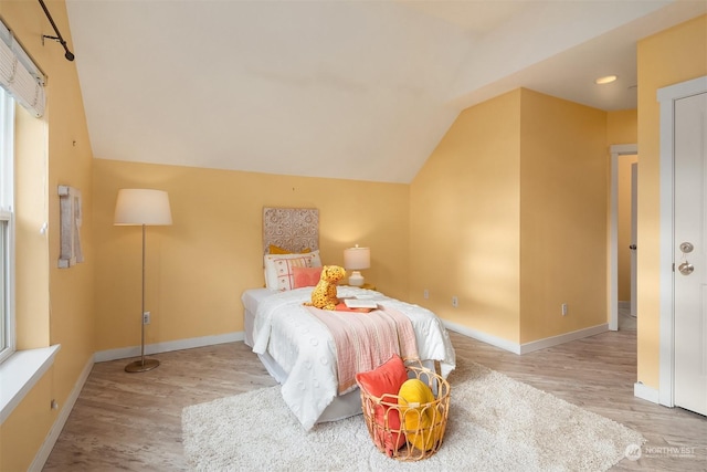 bedroom with lofted ceiling and light hardwood / wood-style floors