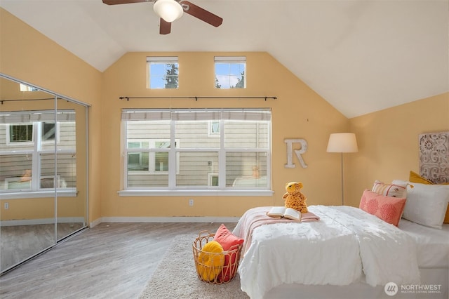 bedroom featuring baseboards, ceiling fan, lofted ceiling, and wood finished floors