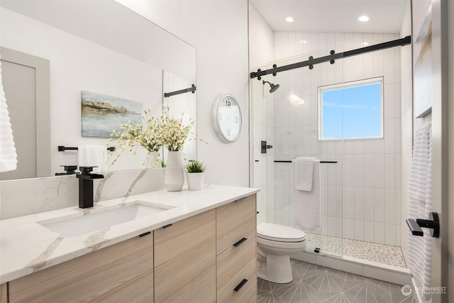 bathroom with vanity, a shower with shower door, and toilet