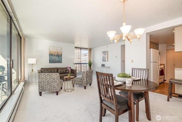 dining space featuring light carpet, an inviting chandelier, a baseboard radiator, and a wall of windows