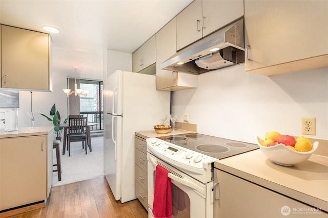 kitchen with light wood-style floors, white appliances, light countertops, and under cabinet range hood