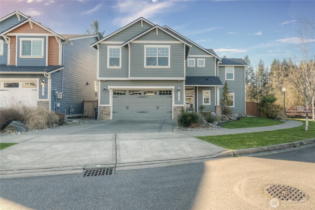 craftsman house with stone siding, concrete driveway, an attached garage, and fence