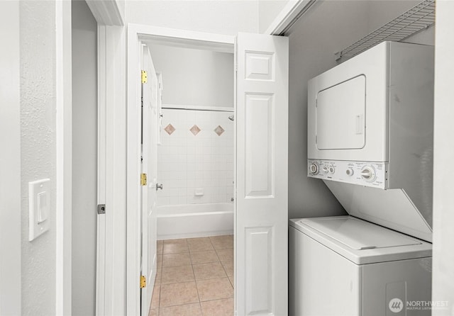 laundry room with stacked washer / dryer, laundry area, and light tile patterned floors