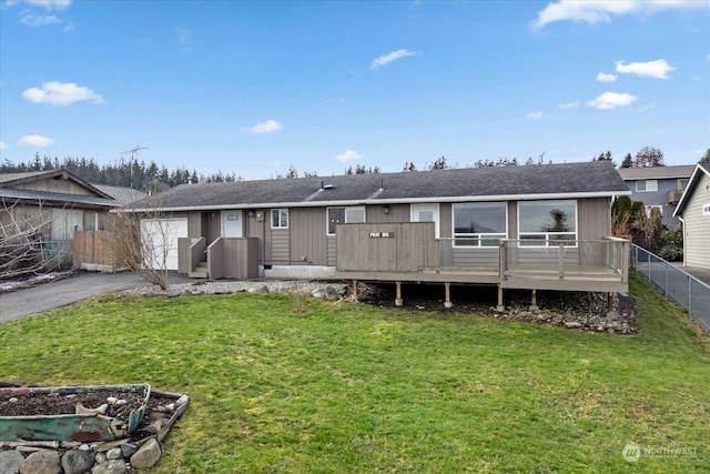 back of property featuring a deck and a lawn