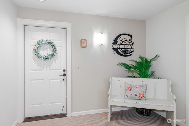 carpeted entryway featuring baseboards