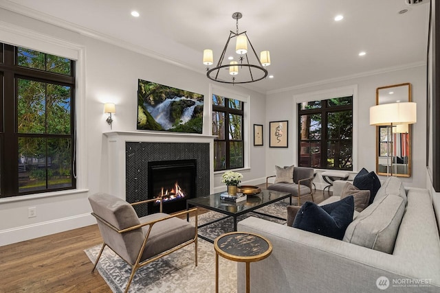 living area featuring recessed lighting, ornamental molding, wood finished floors, a tile fireplace, and baseboards