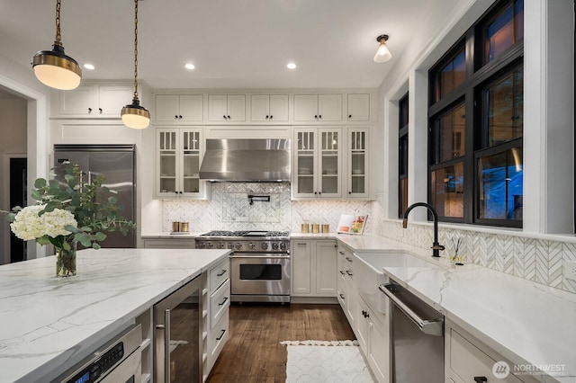 kitchen featuring wine cooler, light stone counters, high quality appliances, range hood, and decorative light fixtures