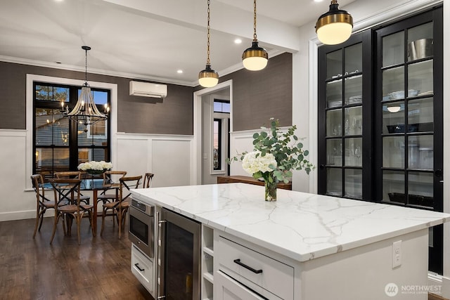 kitchen with a wall unit AC, beverage cooler, a wainscoted wall, white cabinetry, and stainless steel microwave