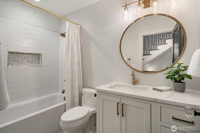 full bath with toilet, shower / tub combo, vanity, and tile walls