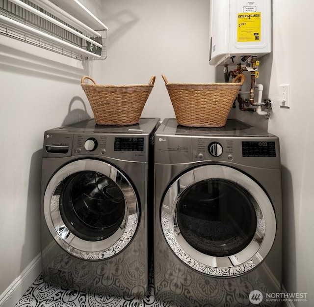 laundry room featuring water heater, laundry area, washing machine and clothes dryer, and baseboards