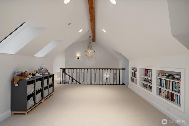 additional living space with carpet floors, vaulted ceiling with skylight, and built in features