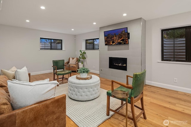 living room with a fireplace, baseboards, wood finished floors, and recessed lighting