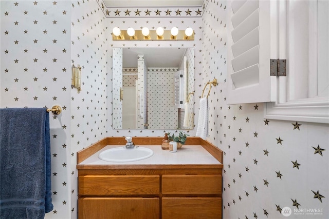 bathroom with vanity and wallpapered walls