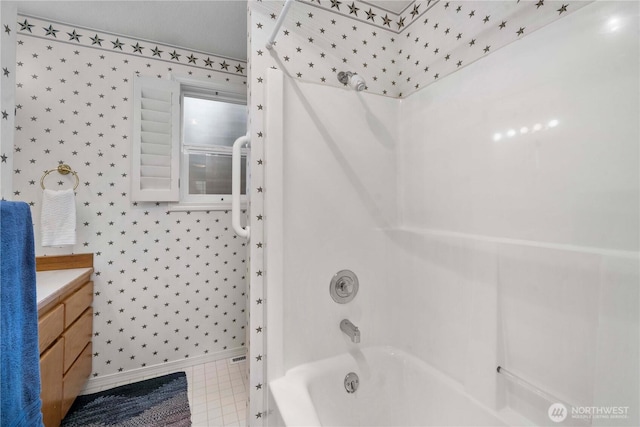 bathroom featuring wallpapered walls, bathtub / shower combination, baseboards, and vanity