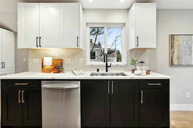 kitchen featuring white cabinetry, dishwasher, sink, decorative backsplash, and light wood-type flooring