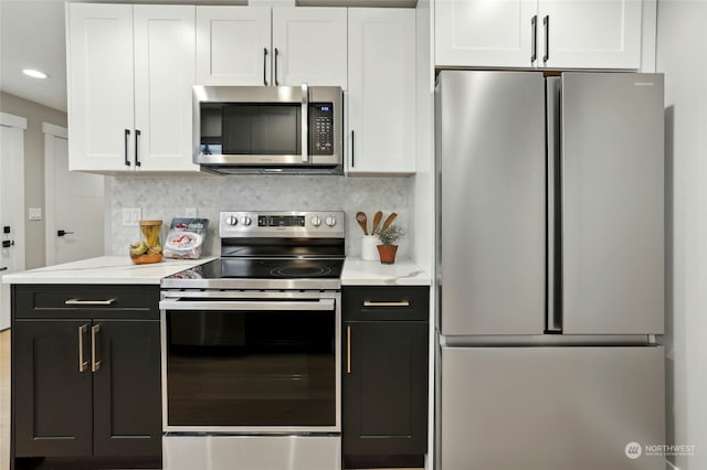 kitchen with backsplash, stainless steel appliances, and white cabinets