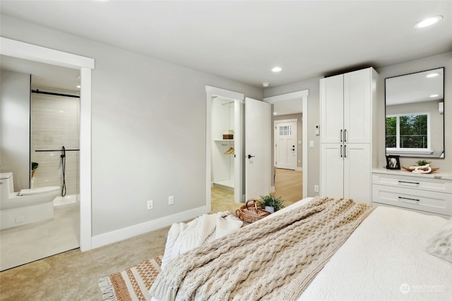 bedroom featuring light colored carpet and ensuite bath