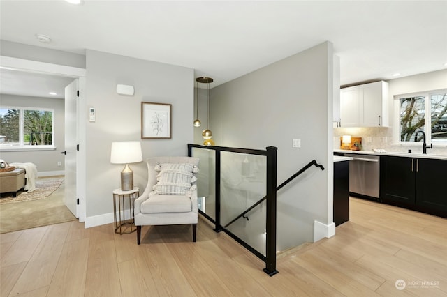 sitting room with sink, light hardwood / wood-style flooring, and plenty of natural light