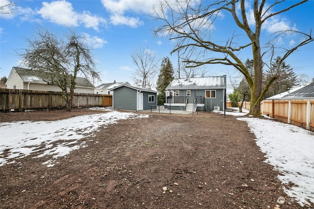 snow covered rear of property with a storage shed