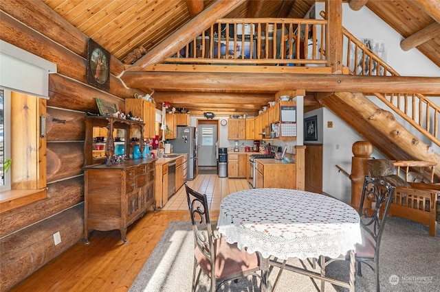 dining space with rustic walls, high vaulted ceiling, wooden ceiling, beamed ceiling, and light wood-type flooring