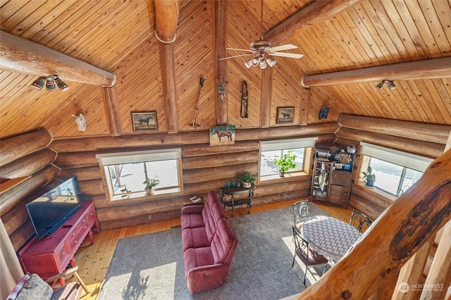 living room with hardwood / wood-style flooring, a high ceiling, wooden ceiling, and beam ceiling