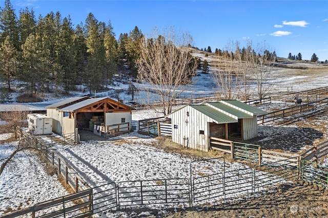 yard layered in snow featuring an outdoor structure and a rural view