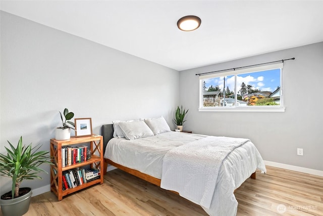 bedroom with light wood-type flooring and baseboards