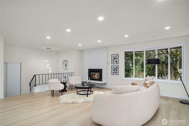 living area with light wood-type flooring, a fireplace, baseboards, and recessed lighting