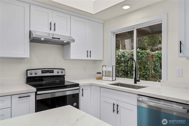 kitchen with appliances with stainless steel finishes, white cabinets, a sink, and under cabinet range hood