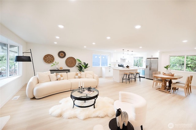 living room featuring a wealth of natural light, light wood-style flooring, and recessed lighting