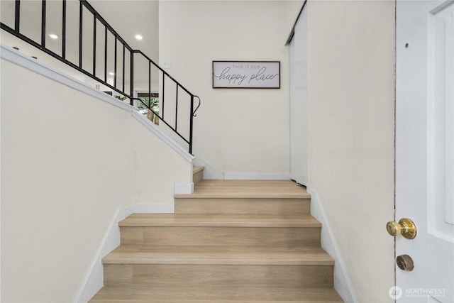 stairs featuring wood finished floors and baseboards