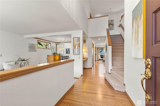 entryway featuring stairs, light wood finished floors, and baseboards