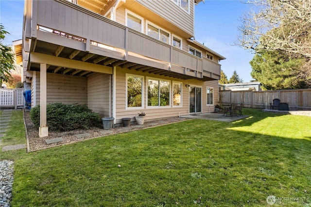 back of house with fence, a lawn, and a patio