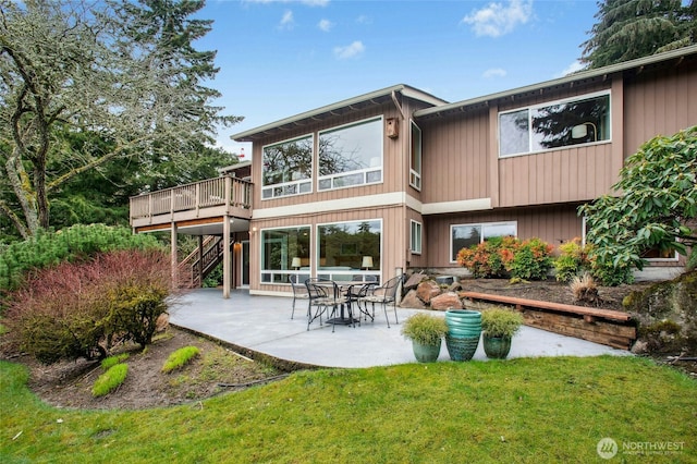 rear view of house with a patio, a lawn, a deck, and stairs