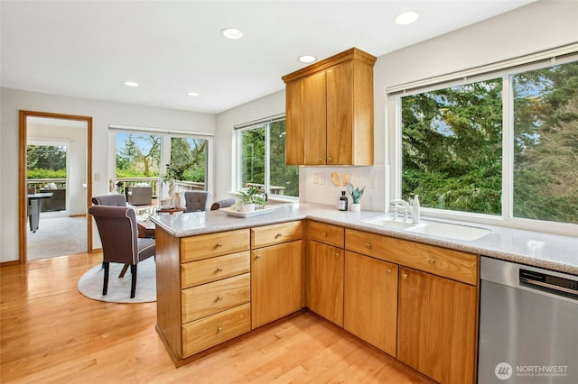 kitchen with light wood finished floors, recessed lighting, a peninsula, stainless steel dishwasher, and a sink