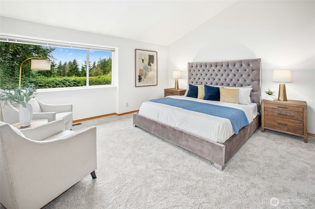 carpeted bedroom with lofted ceiling and baseboards