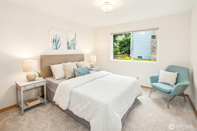 bedroom featuring light colored carpet and baseboards