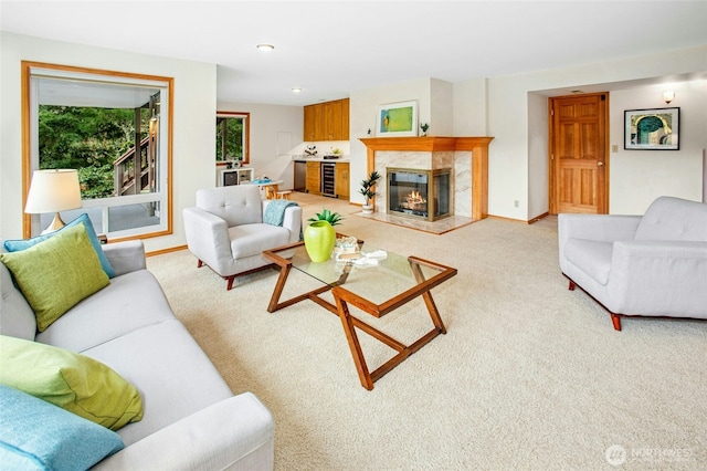 living area with a high end fireplace, baseboards, wine cooler, light colored carpet, and recessed lighting