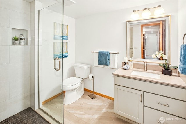 full bath featuring baseboards, vanity, toilet, and a shower stall