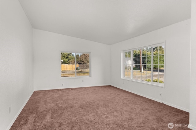 carpeted spare room featuring lofted ceiling