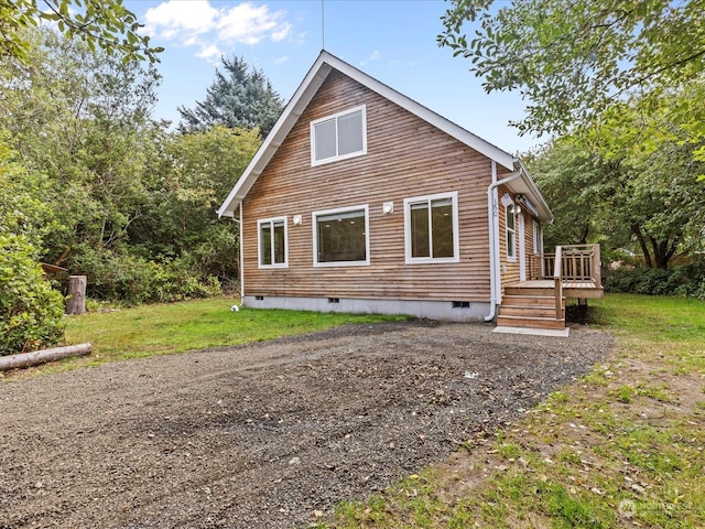 view of side of property featuring a yard and a deck