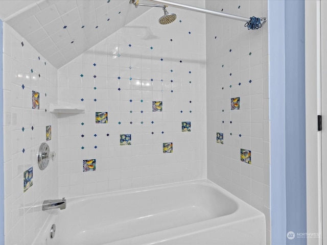 bathroom featuring tiled shower / bath and lofted ceiling