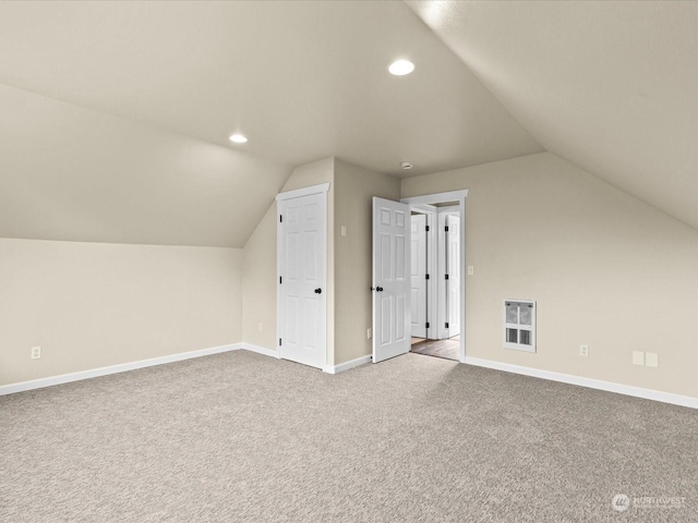 additional living space featuring lofted ceiling and light colored carpet