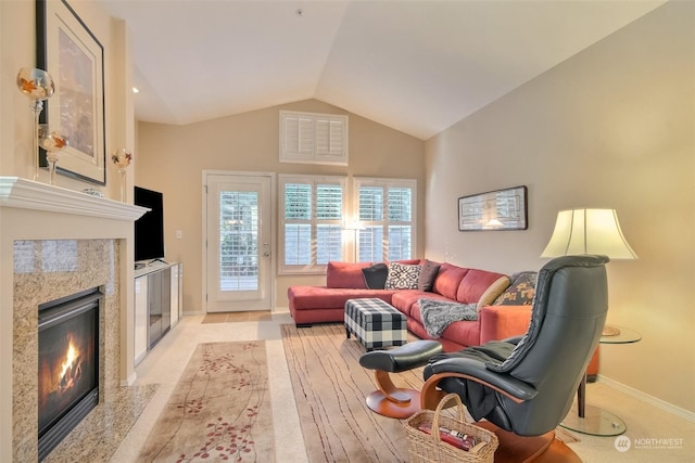 living room featuring lofted ceiling and a high end fireplace